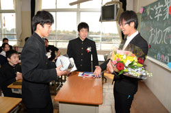 写真：式を終え、花束をプレゼントされた担任